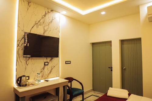 a hotel room with a sink and a tv on a wall at Anirudh Homestay in Agra