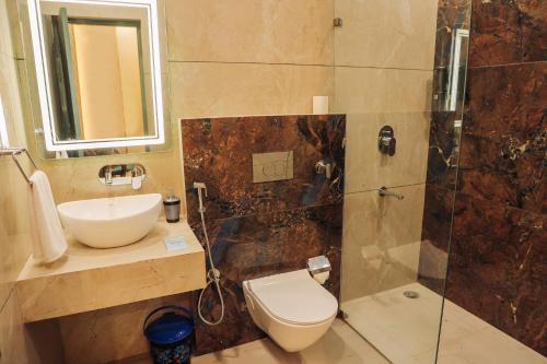 a bathroom with a toilet and a sink and a shower at Anirudh Homestay in Agra