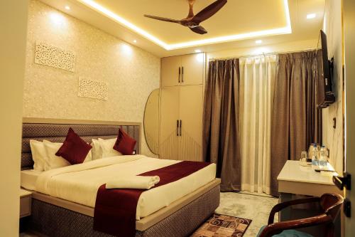 a bedroom with a bed and a desk and a ceiling fan at Anirudh Homestay in Agra