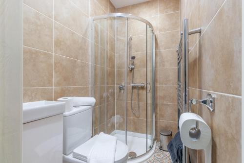 a bathroom with a toilet and a glass shower at Central 2 Bed flat in City Centre with Ensuites and Workspaces in Coventry