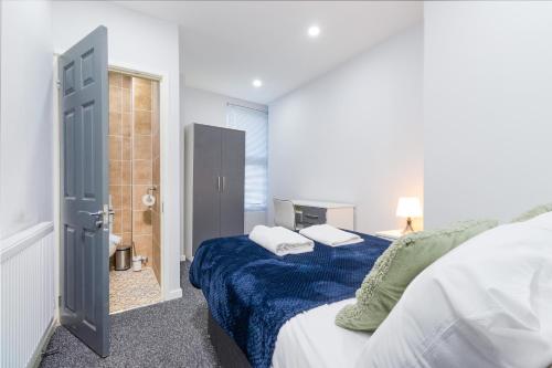 a bedroom with a bed and a bathroom with a shower at Central 2 Bed flat in City Centre with Ensuites and Workspaces in Coventry