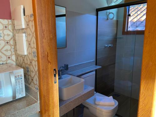 a bathroom with a sink and a toilet and a shower at Pouso Lumiar in Lavras Novas