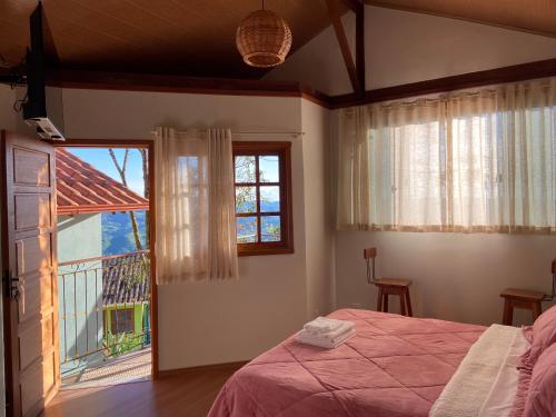 a bedroom with a bed and a large window at Pouso Lumiar in Lavras Novas