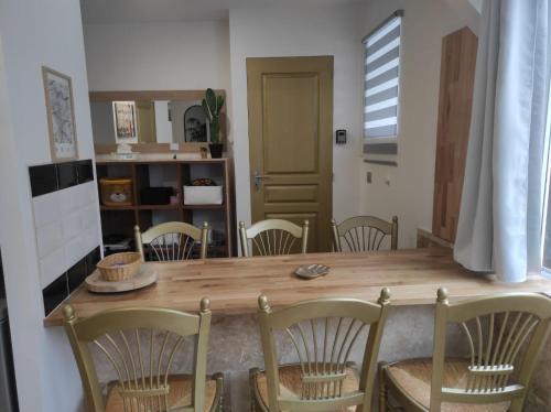 een eetkamer met een houten tafel en stoelen bij résidence luxe césar aeroport tillé 7 personnes in Tillé