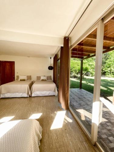 2 łóżka w sypialni z przesuwanymi szklanymi drzwiami w obiekcie Punta Mango Surf Resort w mieście Jucuarán