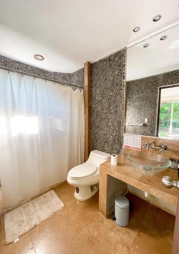 W łazience znajduje się toaleta, umywalka i lustro. w obiekcie Punta Mango Surf Resort w mieście Jucuarán