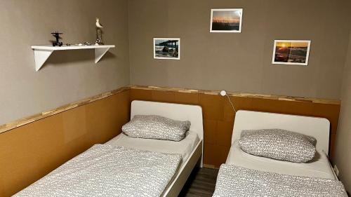 キュールングスボルンにあるBungalow zur Kühlungのベッド2台と棚付きの部屋
