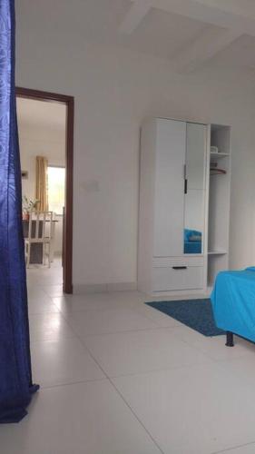 uma sala de estar com um sofá azul e um armário em Apartamento bem localizado em Joinville