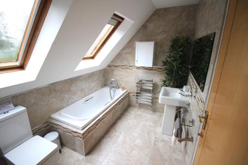 a bathroom with a bath tub and a sink at Picturesque 4 Bed Cottage Lingfield, Surrey in Felbridge