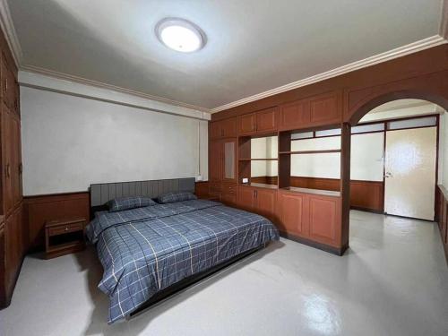 a bedroom with a bed and wooden cabinets at Foodie Heaven in Thonhuri