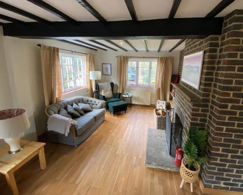 a living room with a couch and a fireplace at Picturesque 4 Bed Cottage Lingfield, Surrey in Felbridge