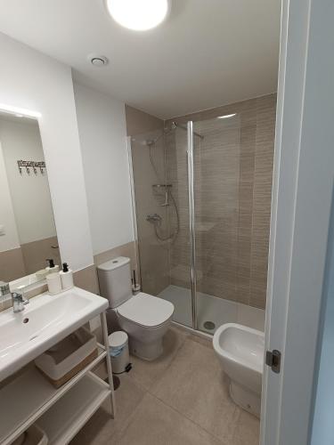 a bathroom with a shower and a toilet and a sink at Casa adosada Rompeolas-Atlanterra in Zahara de los Atunes
