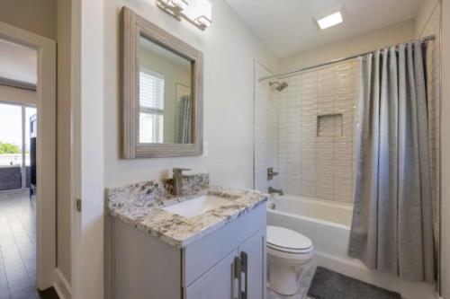 a bathroom with a sink and a toilet and a mirror at Luxury four-story Home with Rooftop views, 10min to Downtown! Sleeps 12! in Nashville