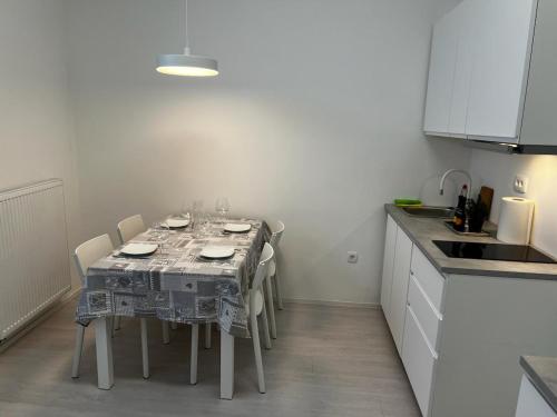 a kitchen with a table with chairs and a tablecloth on it at Elena Apartments in Ljubljana