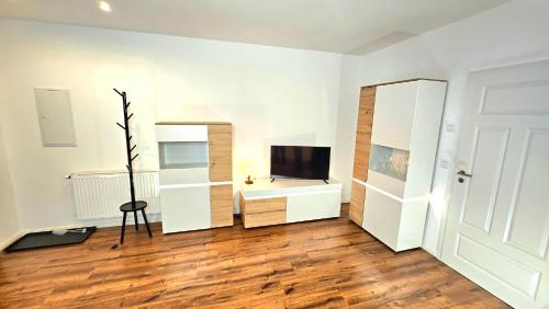 a white room with a desk and a television at Ferienwohnungen An den SchwabachAuen - Keine Monteure in Eckental