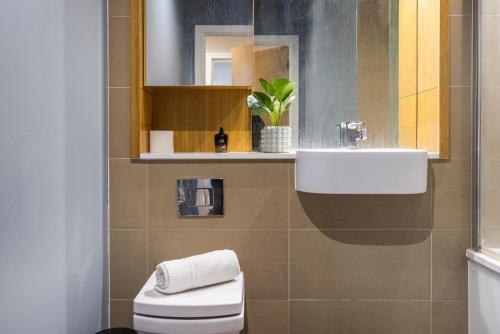 La salle de bains est pourvue d'un lavabo et de toilettes. dans l'établissement Luxury 1 BR Near Westfield Stratford - 10 Min Walk, à Londres