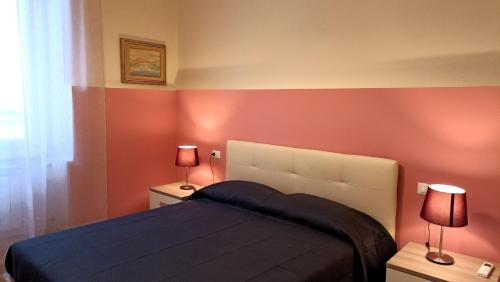 a bedroom with a bed and two lamps on tables at LE VOCI DELLA FONTANA in La Spezia