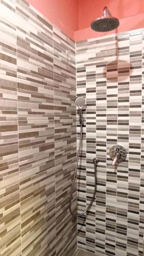 a shower in a bathroom with a tile wall at LE VOCI DELLA FONTANA in La Spezia