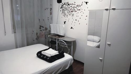 Airbnb Ferentella في تريفيزو: غرفة صغيرة بها سرير ومرآة