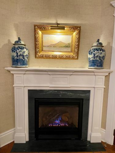 a fireplace with two blue and white vases on top at Hannum House in Skaneateles