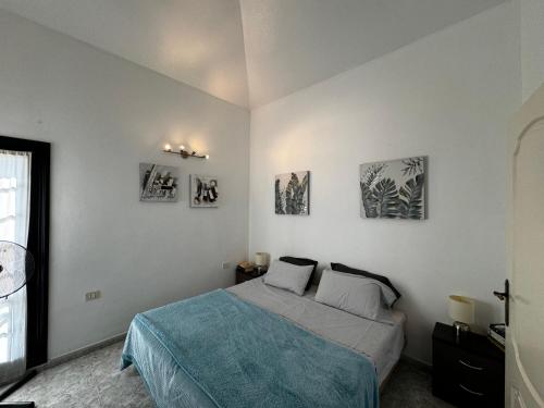 1 dormitorio con 1 cama con 4 cuadros en la pared en Sotavento 28, en Los Cristianos