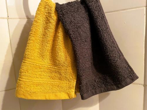 toalla amarilla colgada en la pared del baño en Home Feeling Neneu Lodge, en Moshi