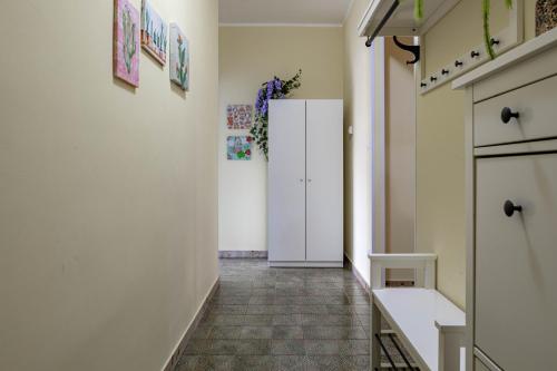a hallway with a white door and a tile floor at H11 [House of Colors] Parcheggio in Taggia