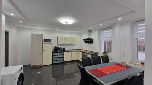 - une cuisine et une salle à manger avec une table et une cuisine dans l'établissement CT Apartment Wurzen, à Wurzen