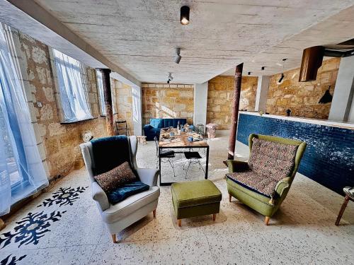 a living room with chairs and a table in a room at The Hidden Gem Of Bordeaux in Lormont