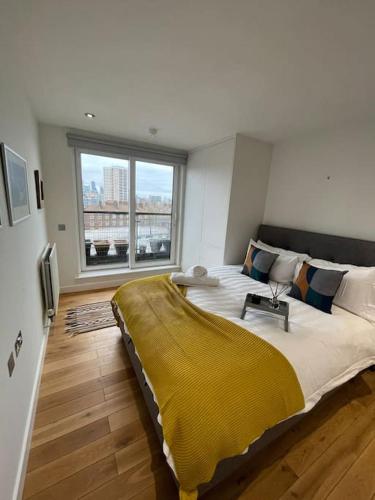 Un dormitorio con una cama grande con una manta amarilla. en Luxury 2Bed 2Bath City View Flat, en Londres