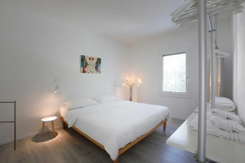 a white bedroom with a bed and a window at Residence Gonda&Giuliano in Borso del Grappa