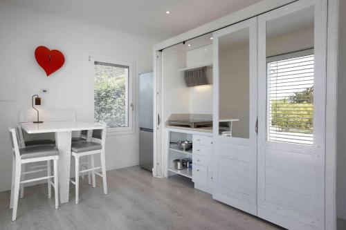 a white kitchen with a table and a heart on the wall at Residence Gonda&Giuliano in Borso del Grappa