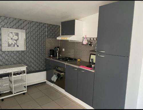 a small kitchen with a refrigerator and a sink at Maisonnette les fabrettes in Marseille
