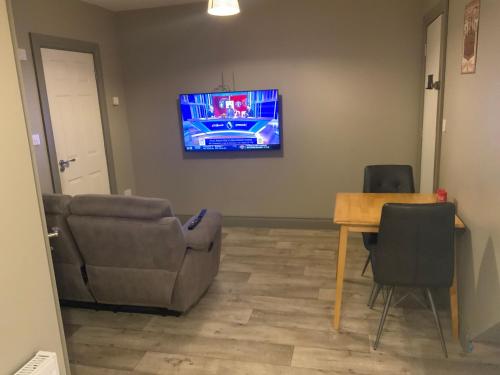 a living room with a couch and a table and a tv at Cozy small 1 bedroom apartment in Galway
