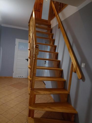 a wooden staircase in a room with a door at DOM w JESIONACH Brajniki - działka 1 HEKTAR in Jedwabno
