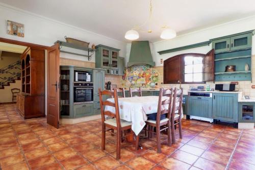 a kitchen with blue cabinets and a table and chairs at Quinta Azul in Moncarapacho