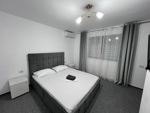 ein Schlafzimmer mit einem Bett mit einem schwarzen Buch darauf in der Unterkunft Casa TIBI și Nico in Eforie Nord