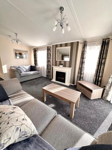 a living room with a couch and a table at Bluebell Lodge, Dog Friendly in South Cerney