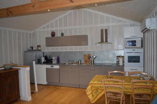 a kitchen with a table and chairs in a room at La cabane du Truquet in Lège-Cap-Ferret