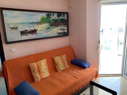 an orange couch in a room with a painting at BRISA Solo FAMILIAS in Los Mártires