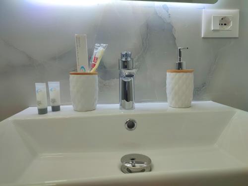 BP Beach Apartment في غوليم: مغسلة الحمام عليها فرش اسنان وكاسين