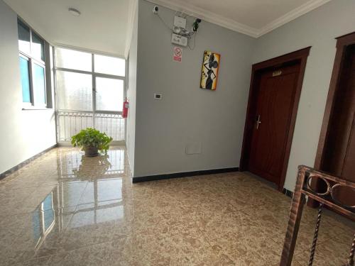 an empty room with a hallway with a door and a plant at Filimon Guest House in Addis Ababa