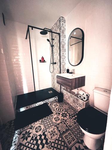 une salle de bain avec un lavabo, des toilettes et un miroir dans l'établissement Bel appartement residentiel, à Ifs