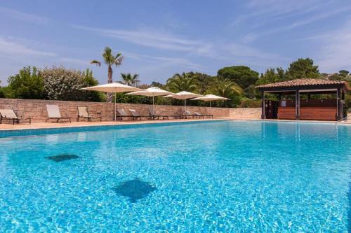 une grande piscine bleue avec chaises et parasols dans l'établissement SAINT TROPEZ-Golf view, à Saint-Tropez