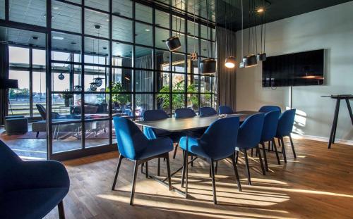 una sala de conferencias con una mesa de madera y sillas azules en Harbour Living by Jutlandia en Frederikshavn