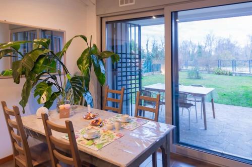 une salle à manger avec une table et une porte en verre dans l'établissement Luminoso appartamento con giardino San Bovio, à Peschiera Borromeo