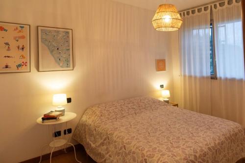 - une chambre avec un lit, une table et une lampe dans l'établissement Luminoso appartamento con giardino San Bovio, à Peschiera Borromeo
