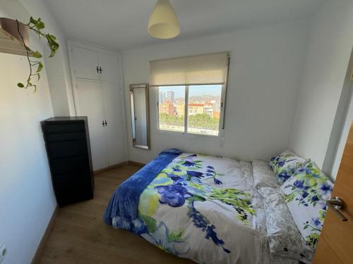 Schlafzimmer mit einem Bett und einem Fenster in der Unterkunft Acogedor apartamento en Málaga in Málaga