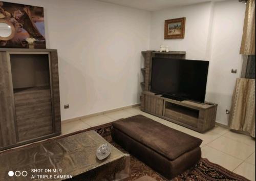a living room with a flat screen tv and a couch at F4 moderne au centre ville d'oran in Oran