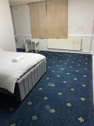 a bedroom with a bed and a blue floor at Cozy spacious double room rm 8 in Oldham